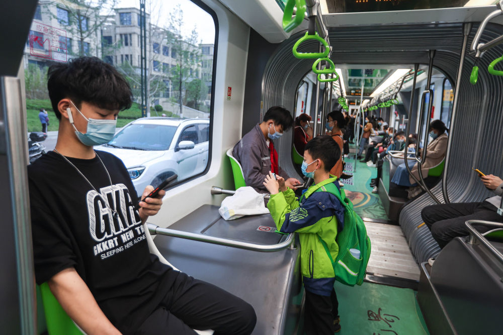 ↑市民乘坐一辆行驶在宜宾市T1运营线上的智轨电车。