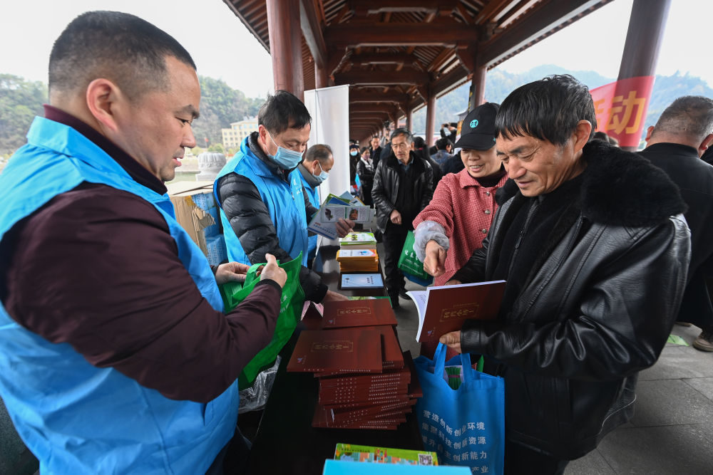 在杭州市临安区昌化镇举行的春季文化科技卫生“三下乡”服务活动上，临安区科学技术协会“三服务”小分队的党员志愿者将科普书籍赠送给当地群众（2023年2月22日摄）。新华社记者 徐昱 摄