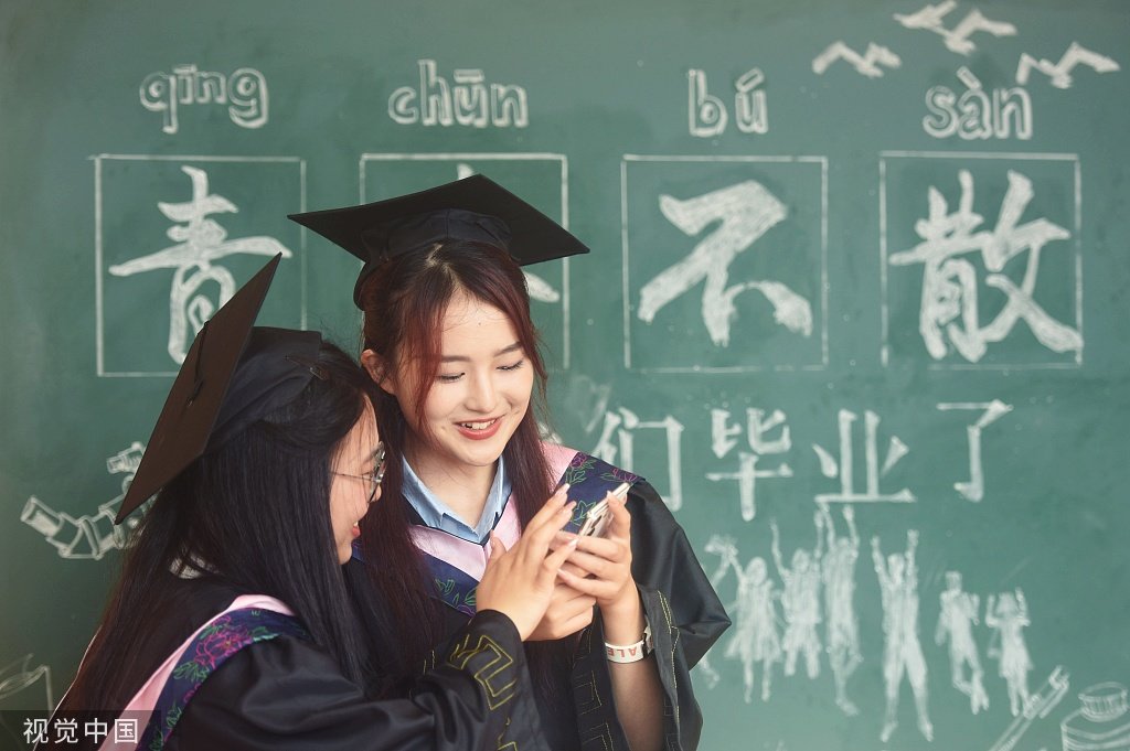 2023年6月25日，杭州，参加毕业典礼的学子在浙大校园拍照留念 图源：视觉中国