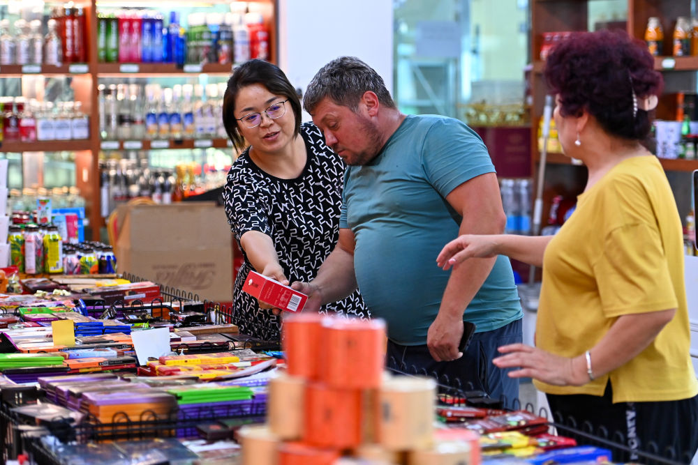 在新疆塔城巴克圖中哈邊民互市絲路文化商品城，一位哈薩克斯坦的游客在選購商品（7月22日攝）。新華社記者丁磊 攝