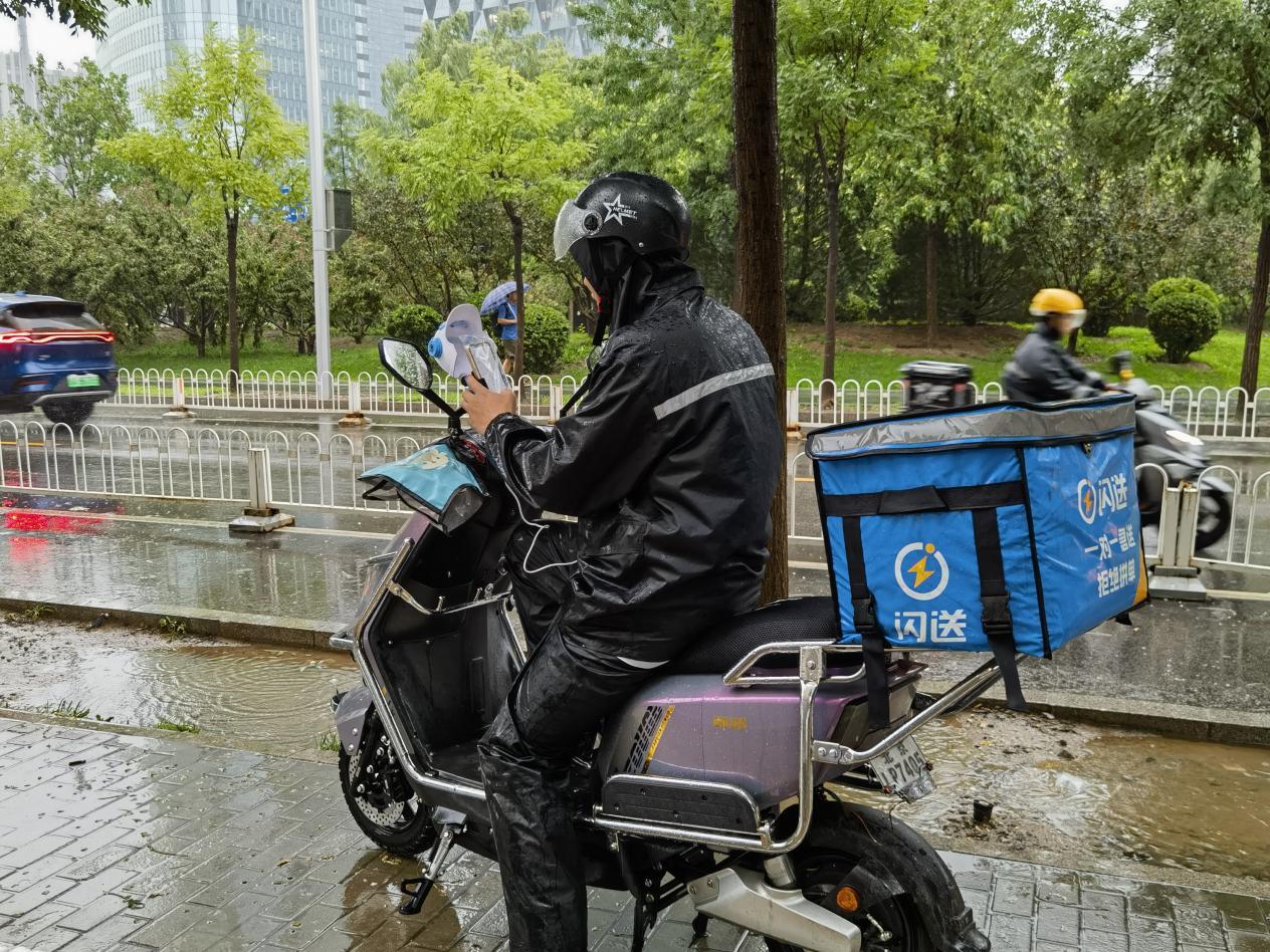 闪送员小凯在雨中 澎湃新闻记者李文姬 摄