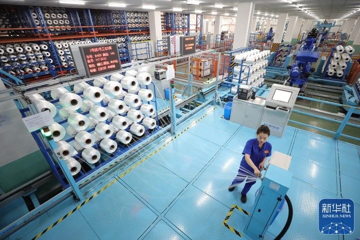 3月15日，在恒力（苏州）产业园内的高性能涤纶工业丝智能车间内，员工对工业丝进行包装前的外检。新华社记者 毛俊 摄