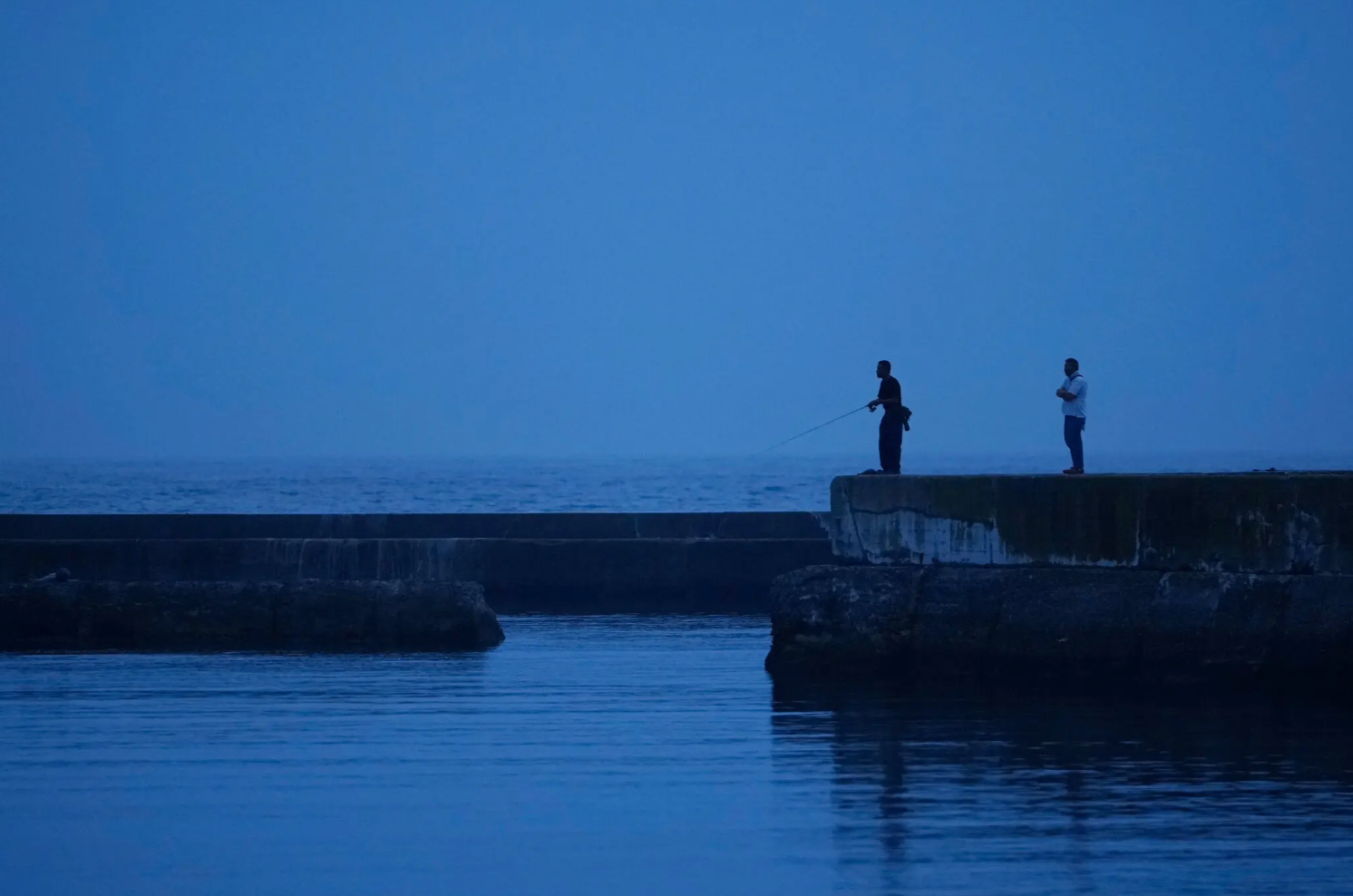 今年7月，日本福島縣磐城市，一男子在某處海港釣魚。圖/美聯(lián)社