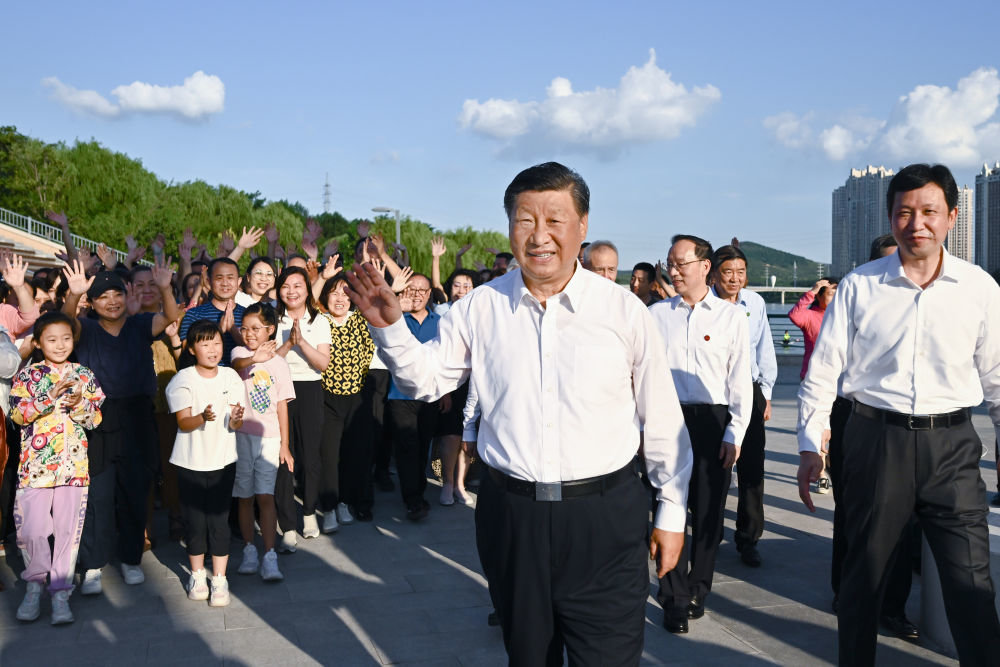 2022年8月16日下午，习近平在辽宁省锦州市东湖森林公园察看小凌河沿岸生态环境时，向群众挥手致意。