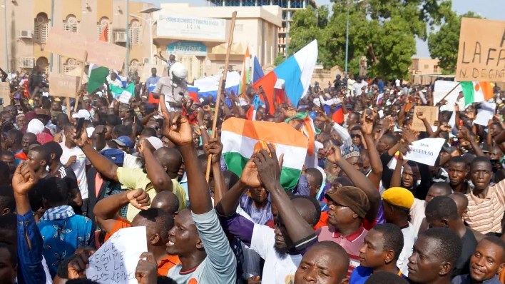 7月30日，支持政变军人的尼日尔示威者高喊反法口号，举着俄罗斯国旗走上街头/CNBC 图