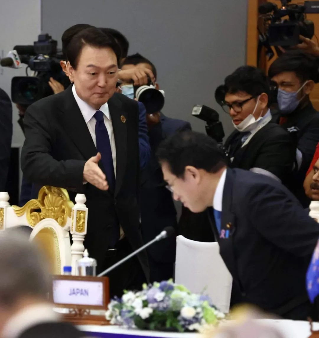 2022年11月13日，柬埔寨金边，韩国总统尹锡悦（左）和日本首相岸田文雄出席会议期间相互问候。图/视觉中国