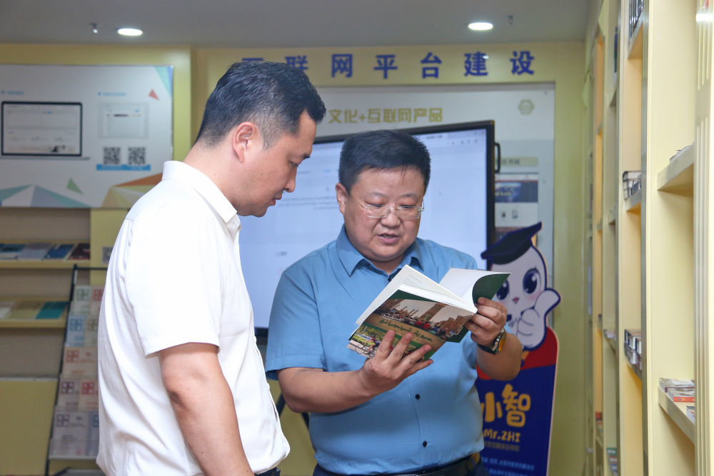 张时荣代表（右）在介绍团队翻译的阿文版图书。（受访者供图）