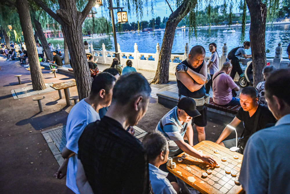 2023年6月10日，市民在北京什刹海边下棋。新华社记者陈钟昊摄