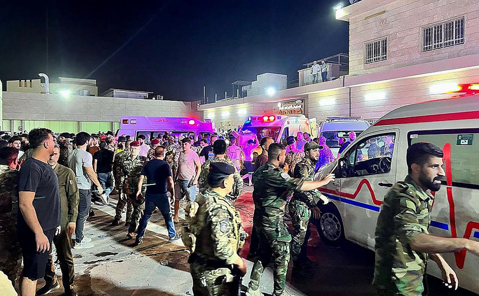 当地时间2023年9月27日，伊拉克哈姆达尼亚综合医院外，士兵和紧急救援人员聚集在运送伤员的救护车周围。视觉中国 图