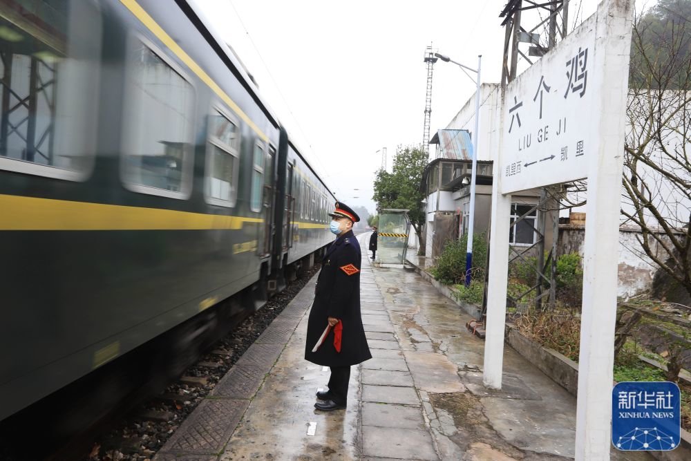1月21日,在贵州六个鸡火车站,外勤值班员吴昌辉在站台接发旅客列车。新华社发(吴吉斌摄)