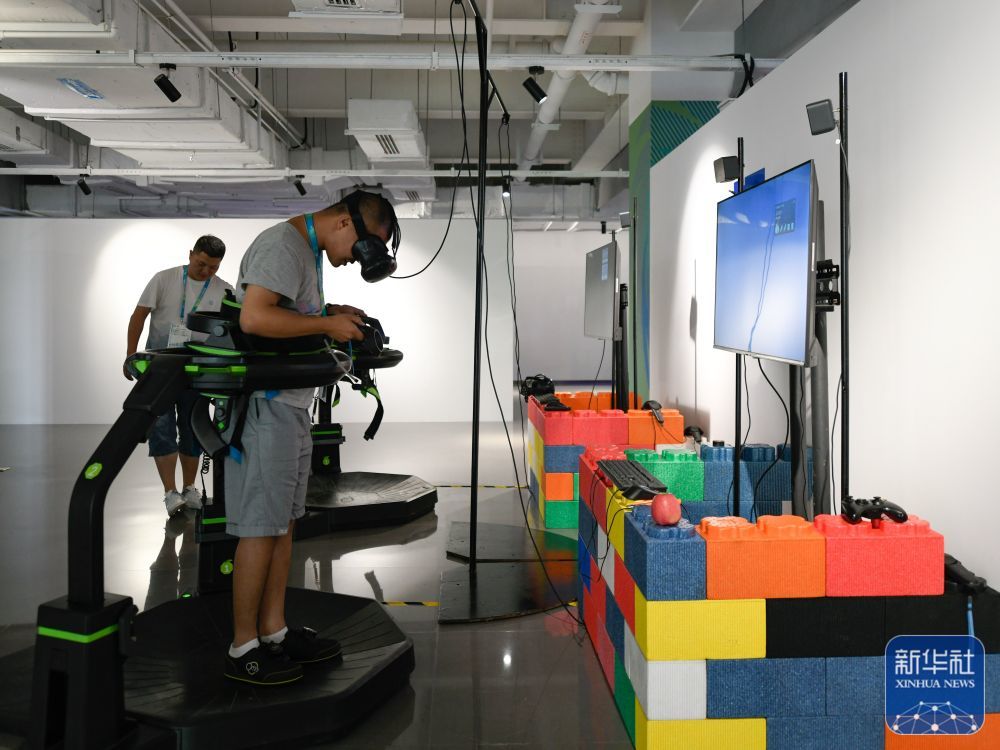 ↑7月14日,媒体工作人员在成都大运会主媒体中心休闲娱乐区内体验VR游戏。新华社记者 胥冰洁 摄