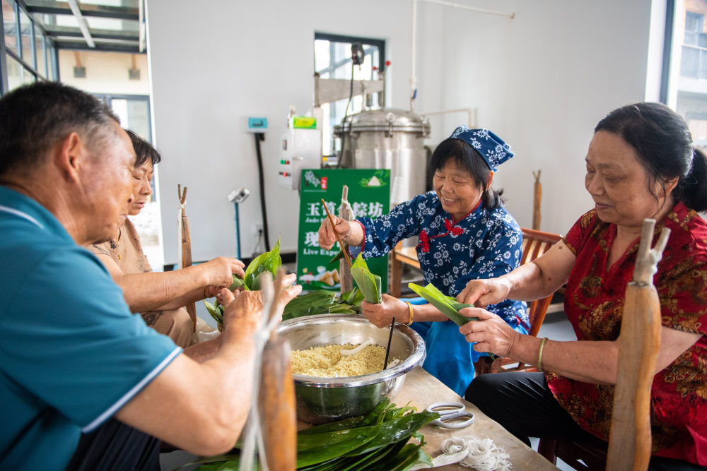 6月22日，在湖南省汨罗市屈子祠镇新义村，村民们在包粽子。新华社记者 陈思汗 摄