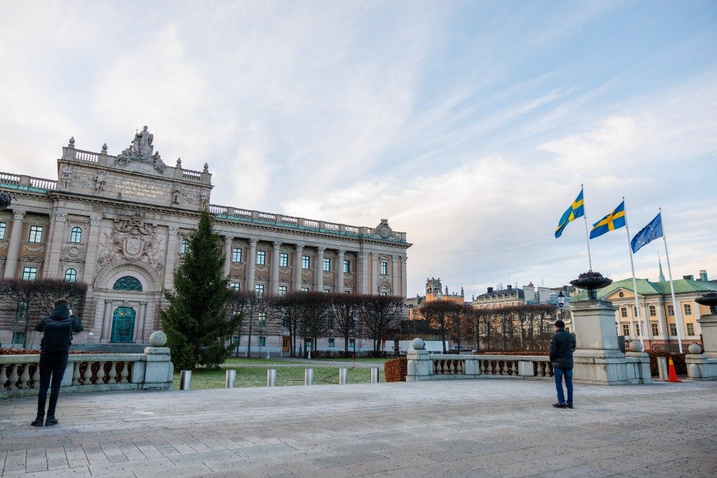 1月1日，在瑞典首都斯德哥尔摩，瑞典议会大楼外悬挂瑞典国旗和欧盟旗帜。新华社发（魏学超摄）