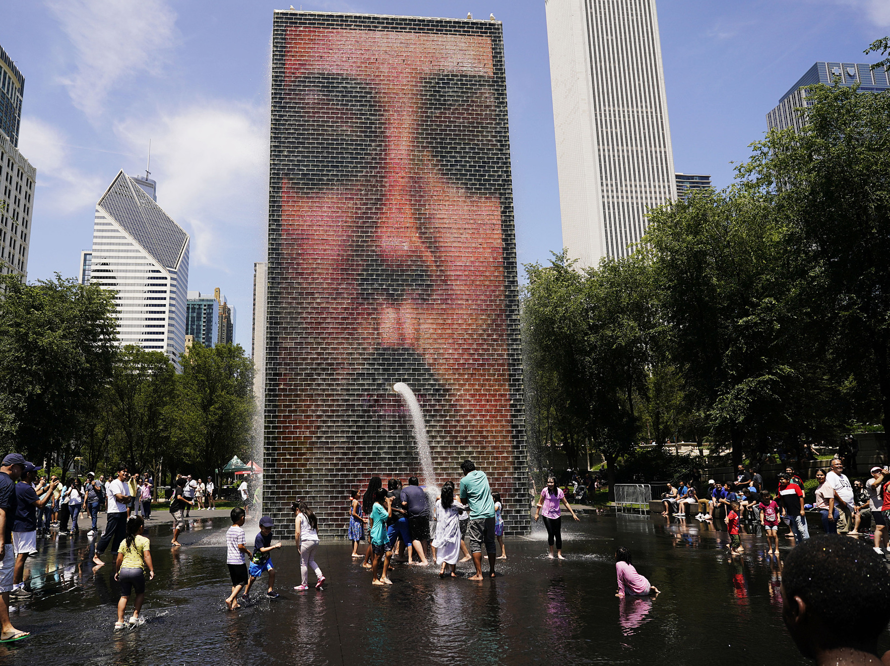 当地时间2023年7月3日，美国芝加哥千禧公园，人们在皇冠喷泉前降温。