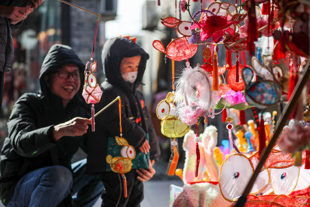 ↑1月20日，市民在江苏扬州东关历史街区购买兔子花灯。新华社发（齐立广 摄）