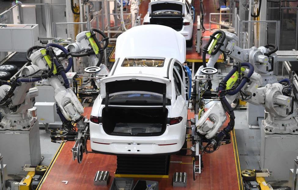 △广州一家新能源汽车生产线，机器人手臂在安装汽车轮胎。