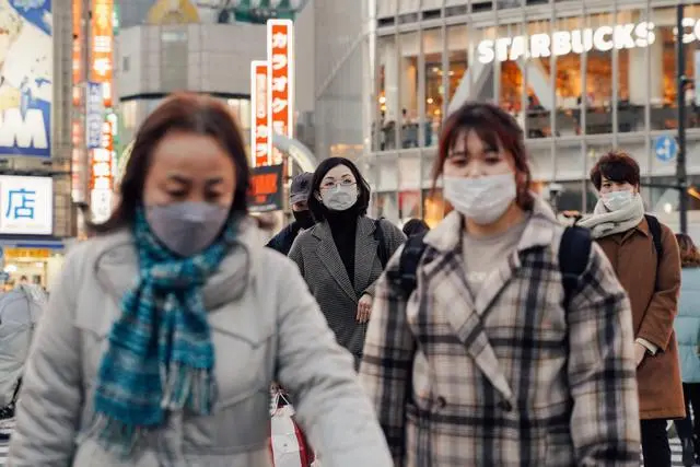 2022年1月21日，人们戴口罩走在日本东京涩谷街头。图｜新华社记者 张笑宇 摄