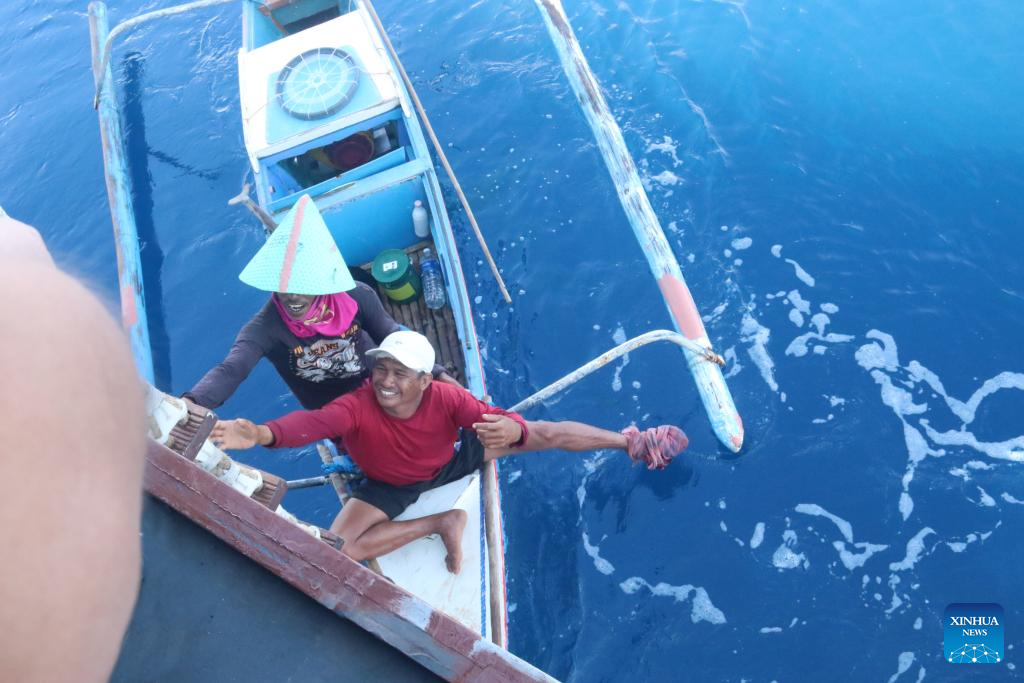 两名菲律宾渔民向中国人民海军“阿坝舰”寻求帮助。图自新华社英文