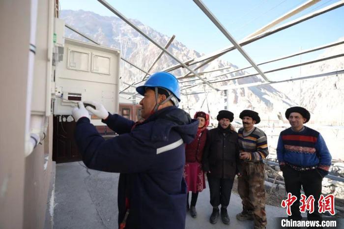 电力员工为牧民们做送电前的最后检查。刘美宏 摄