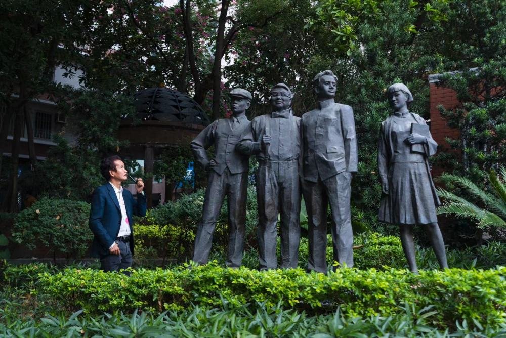 雕塑家许鸿飞与雕塑作品《“东山少爷”“西关小姐”》。（受访者供图）