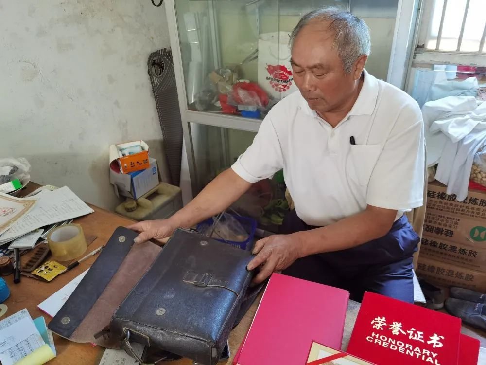 徐德林展示他用了多年的皮革包。