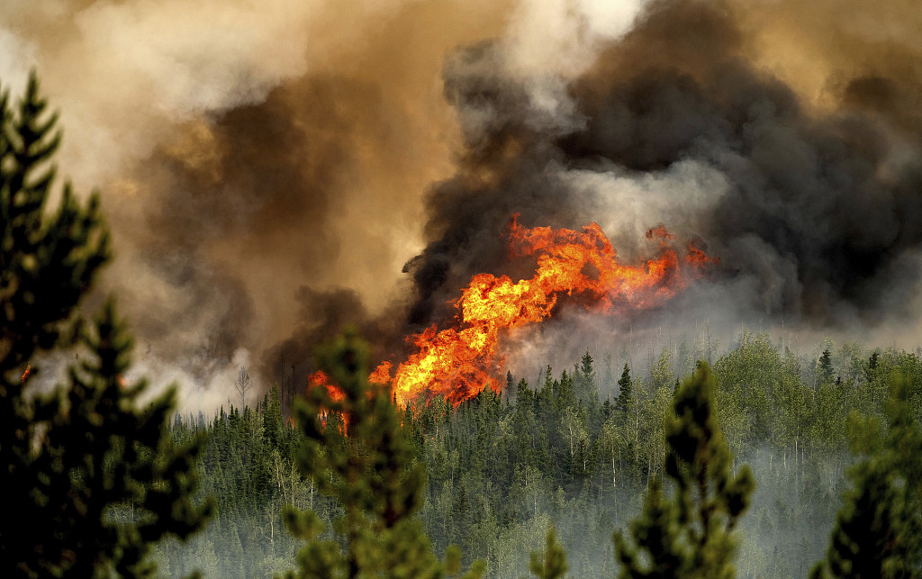 当地时间2023年7月2日，加拿大圣约翰堡，野火的火焰沿着山脊燃烧。