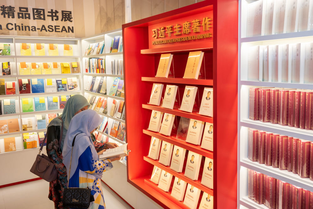 5月30日，两名读者在马来西亚吉隆坡国际书展中国主宾国活动现场阅读习近平主席著作。新华社记者朱炜摄