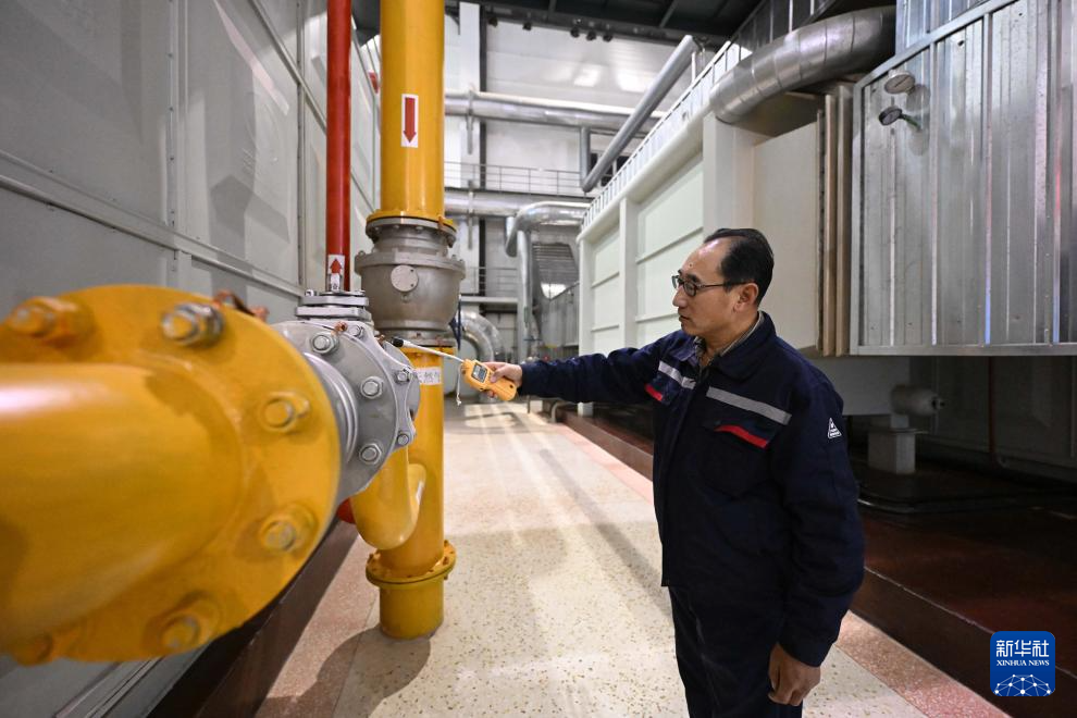 12月22日，在天津市泰嘉热力管理有限公司胜利路供热站，值班人员在夜间值守时使用专业仪器设备对运行中的设备进行巡检。新华社图片