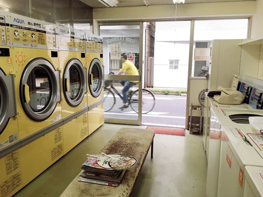 投币式洗衣间内景, 翻翻杂志, 看看来往的路人(摄影:吉井忍)