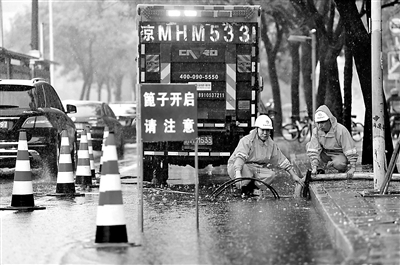 排水集團(tuán)工作人員在學(xué)院路輔路一處積水點(diǎn)進(jìn)行排水作業(yè) 攝影/本報(bào)記者 袁藝