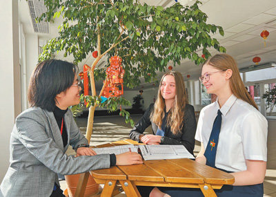 匈中双语学校学生瓦拉加（中）和伊莫瑞（右）与该校孔子课堂中文教师王悦分享收到习近平主席复信的喜悦。　　