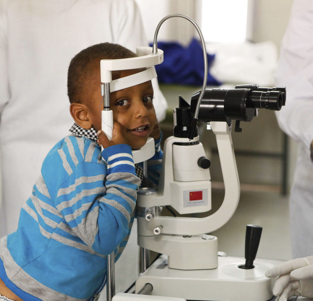 ↑2014年5月2日，在埃塞俄比亚首都亚的斯亚贝巴的阿勒特医院，一名小朋友等待参加“光明行”活动的中国眼科专家为他看诊。新华社记者 李京 摄