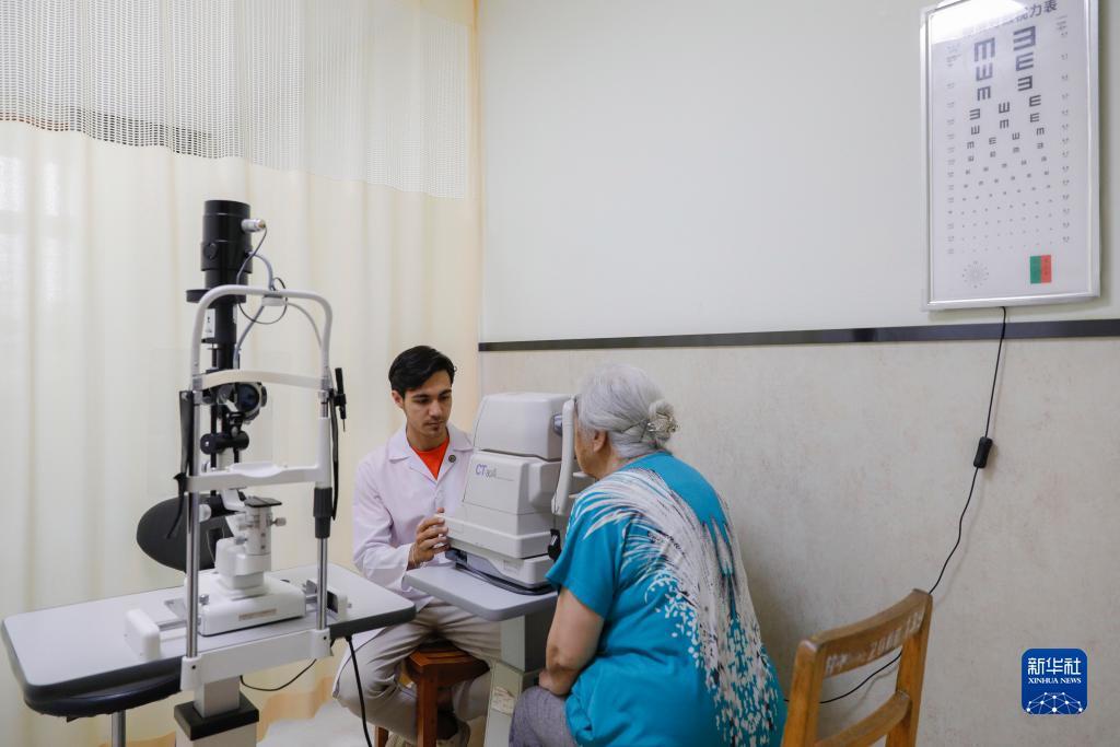 甘肃中医药大学针灸推拿专业的土库曼斯坦留学生迪达（左）在临床实习中为患者检查眼睛（7月28日摄）。新华社记者 方欣 摄