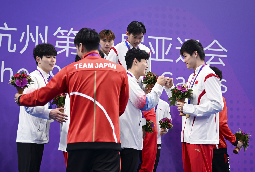 9月28日，中国队选手在男子4X100米自由泳接力决赛后与韩国队和日本队选手致意。