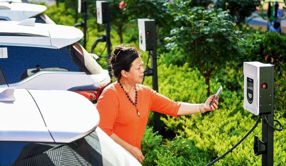 2023年5月24日，山東省膠州市新立街小區內一位居民使用電動汽車充電樁掃碼充電。該小區加裝各類智慧設備，打造“智慧社區”，為居民生活帶來便利。