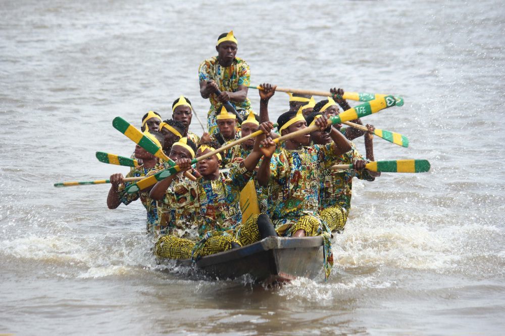 8月26日，贝宁科托努的冈维埃水上村庄，人们身着多彩服饰参加独木舟赛。