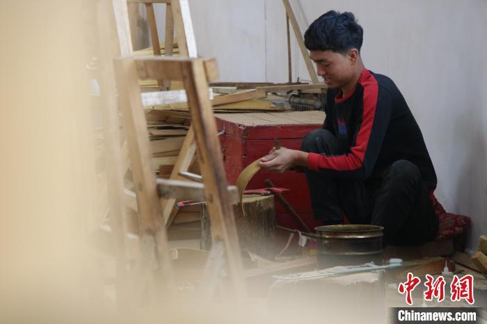 近日,在阿克苏地区新和县依其艾日克镇加依村乐器产业园内,工人们分工明确,忙碌地生产乐器的各个配件。苟继鹏 摄