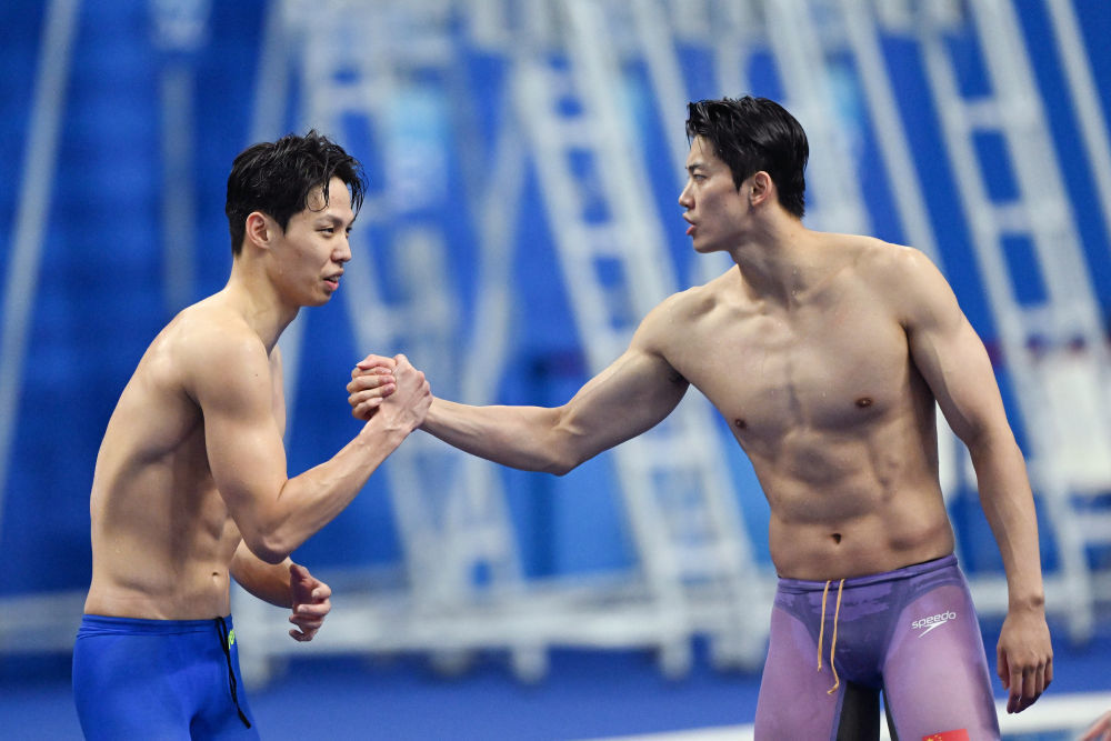 9月25日，韩国队选手金禹旻和中国队选手汪顺（右）在男子4x200米自由泳接力比赛后握手致意。