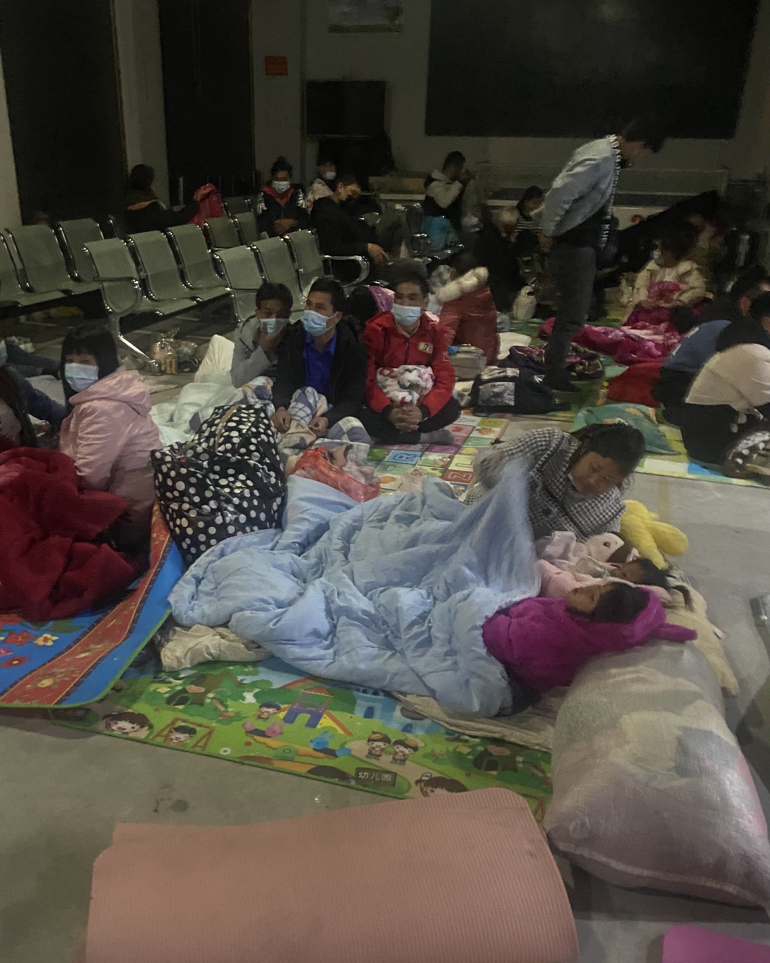 1月12日晚,不少缅籍人员办完相关手续后,直接在服务大厅领了铺盖,席地而睡,等天亮回家。澎湃新闻记者陈灿杰 图
