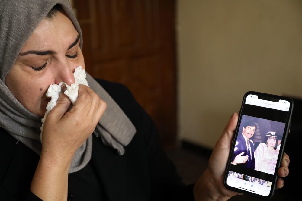 2月14日，在伊拉克北部萨拉赫丁省祖卢耶镇，松杜丝&middot;拉米展示她和丈夫阿米尔的合影。新华社发（哈利勒&middot;达伍德摄）