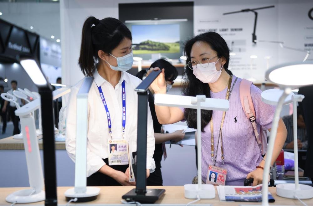 4月15日,采购商(右)和参展商在广交会上交流。新华社记者 邓华 摄