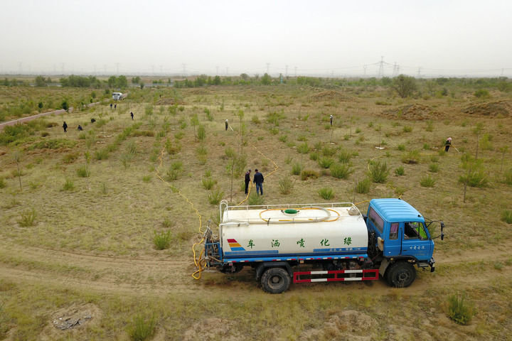 6月2日，在武威市古浪县，八步沙林场职工给一片梭梭林浇水（无人机照片）。新华每日电讯记者 范培珅 摄