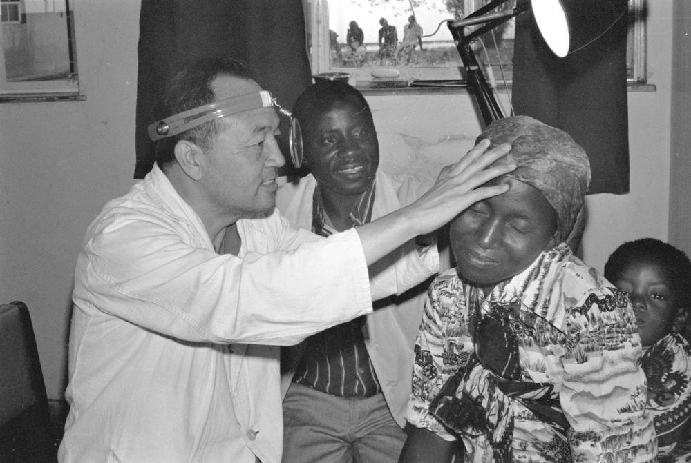 ↑1981年，在赞比亚卡波韦总医院工作的中国医疗队医生为当地群众治病。新华社记者 戈春江 摄