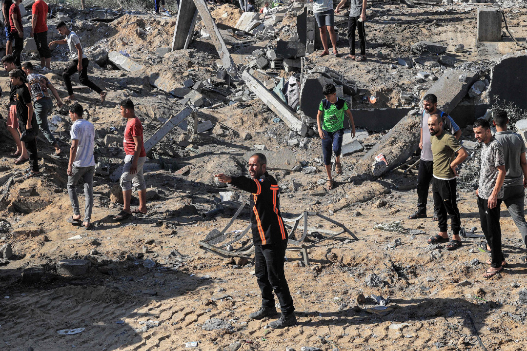 当地时间2023年10月13日，加沙地带拉法省，以色列空袭后，民众在废墟中搜寻遇难者。视觉中国 图