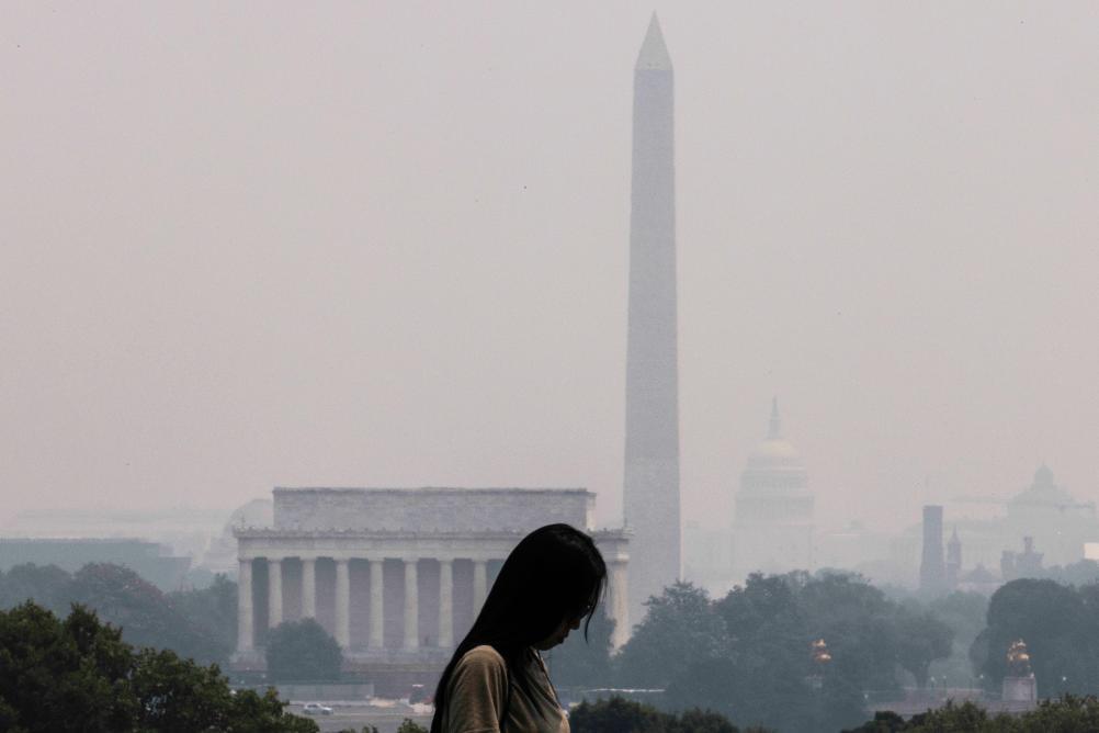 这是6月7日在美国弗吉尼亚州阿灵顿拍摄的烟尘笼罩下的林肯纪念堂、华盛顿纪念碑和国会。（新华社发，亚伦摄）
