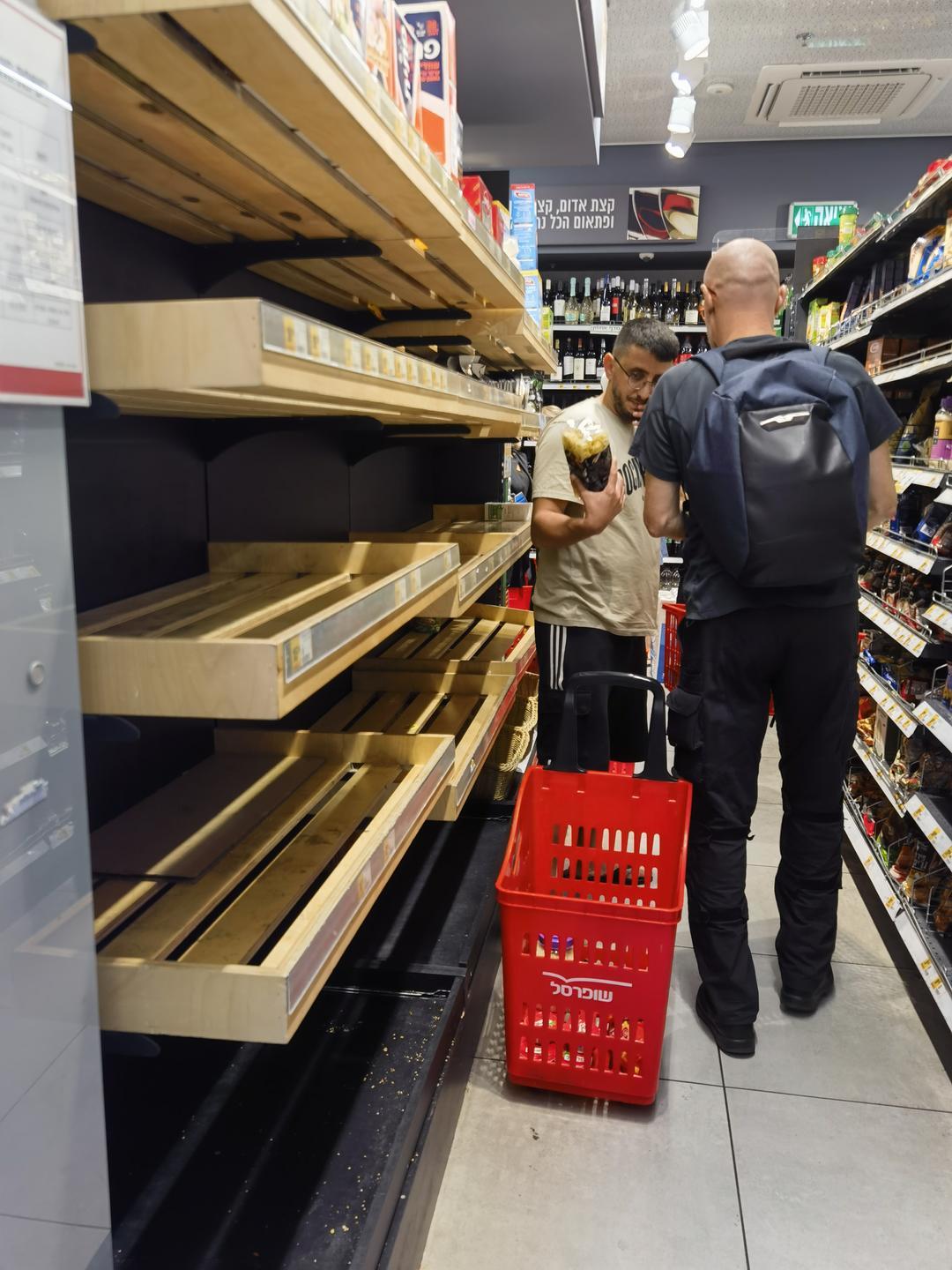▲接到政府通知后，以色列当地居民开始囤粮，超市货架上食品被买空