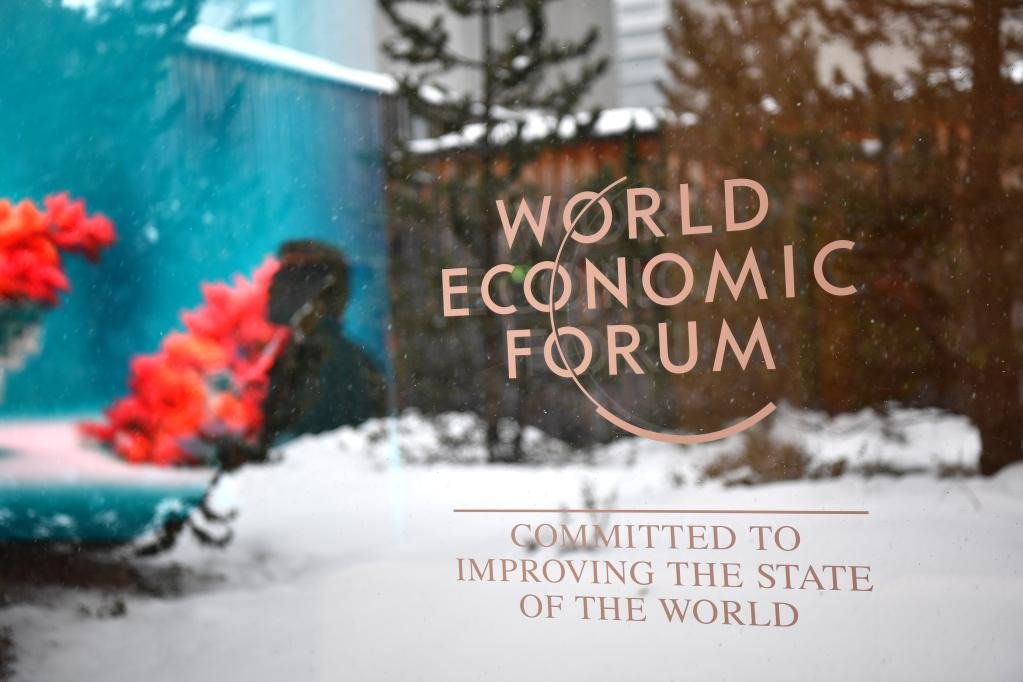 1月15日，在瑞士达沃斯会议中心，与会者从世界经济论坛标志旁走过。新华社记者连漪摄