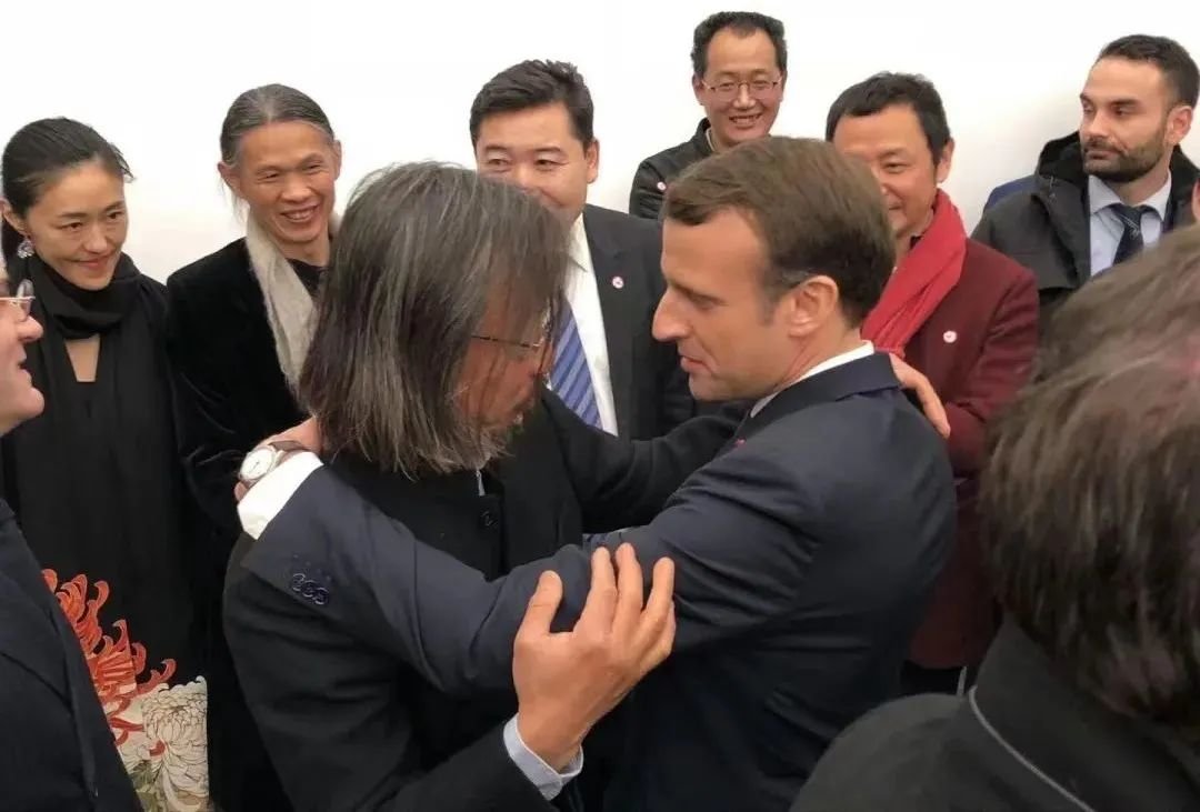 ▲ 2019年,马克龙总统访华时与艺术家黄锐相拥,图源:黎静