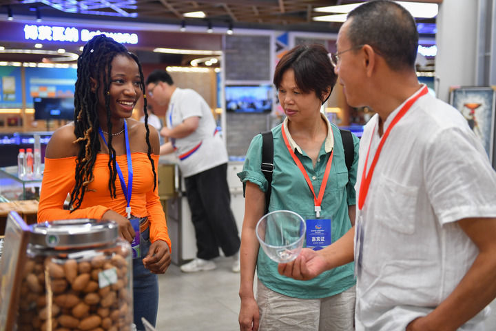 6月30日，在中非经贸合作促进创新示范园（湖南高桥大市场），来自贝宁的志愿者米贝拉（左一）向参观者介绍展品。