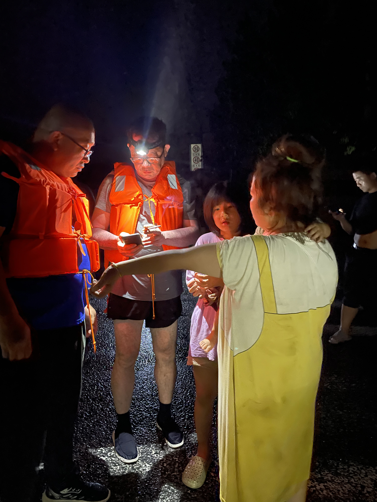 吴婷和孩子获救后，向救援队展示手臂上被困丈夫的电话，希望能够搭救。澎湃新闻记者 陈媛媛 摄